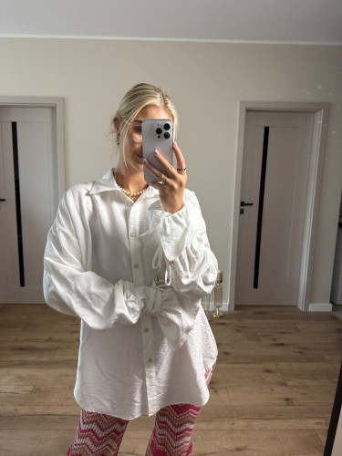 Biały T shirt damski Lamilla z dekoltem V i oversize'owym krojem. Uniwersalna koszulka idealna na lato, wakacje i codzienne stylizacje