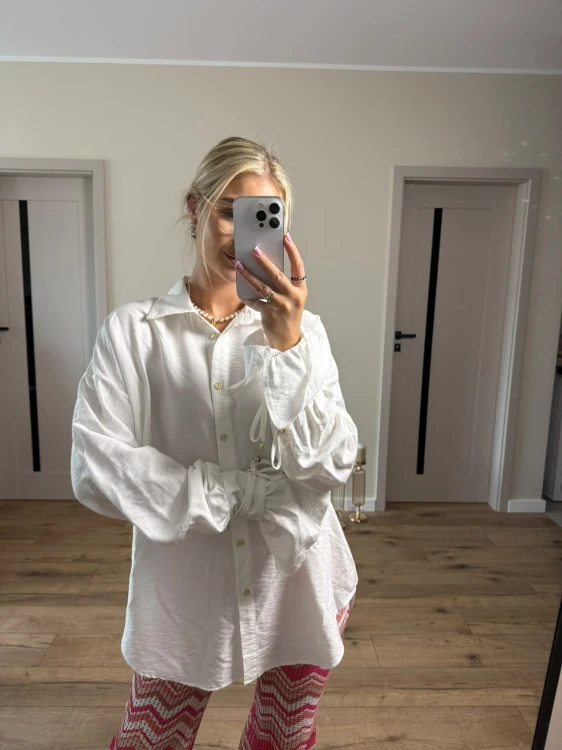Biały T shirt damski Lamilla z dekoltem V i oversize'owym krojem. Uniwersalna koszulka idealna na lato, wakacje i codzienne stylizacje